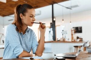 Woman with a ponytail looking at the laptop screen with concentration.